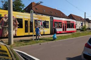 SauberMachathon Kötzschen © OT Kötzschen zwei Bürger sammeln Müll an einer Straßenbahnhaltestelle, im Hintergrund die Straßenbahn